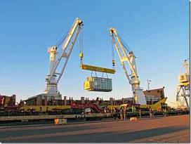 A crane picking up a storage unit